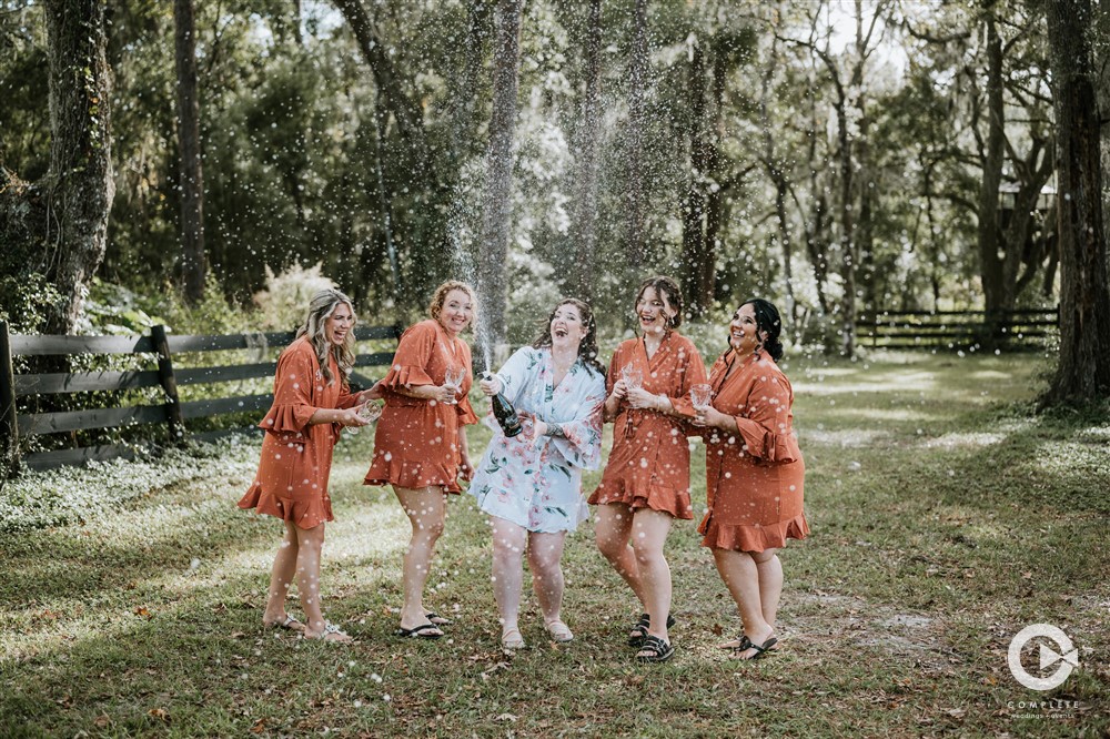 Champagne pop bridesmaids and bride outdoor photo at The Edison Barn in Tampa Bay.